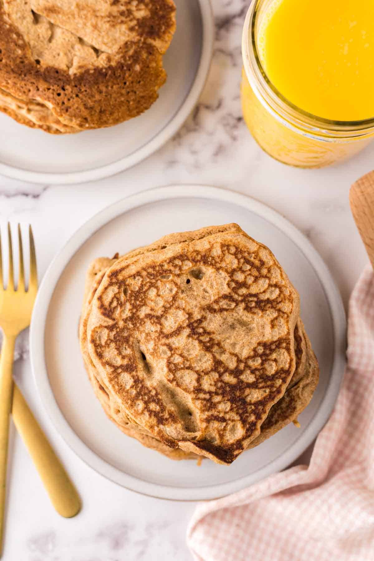 top view of a stack of buckwheat pancakes on a white plate