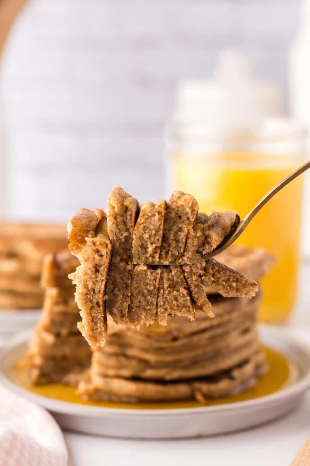 POV forkful of a bite of buckwheat pancakes in layers through the whole stack