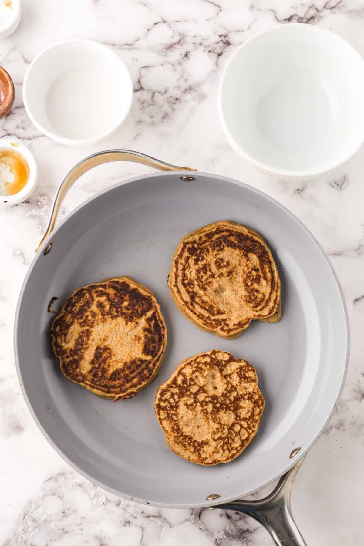 pan with three cooked buckwheat pancakes