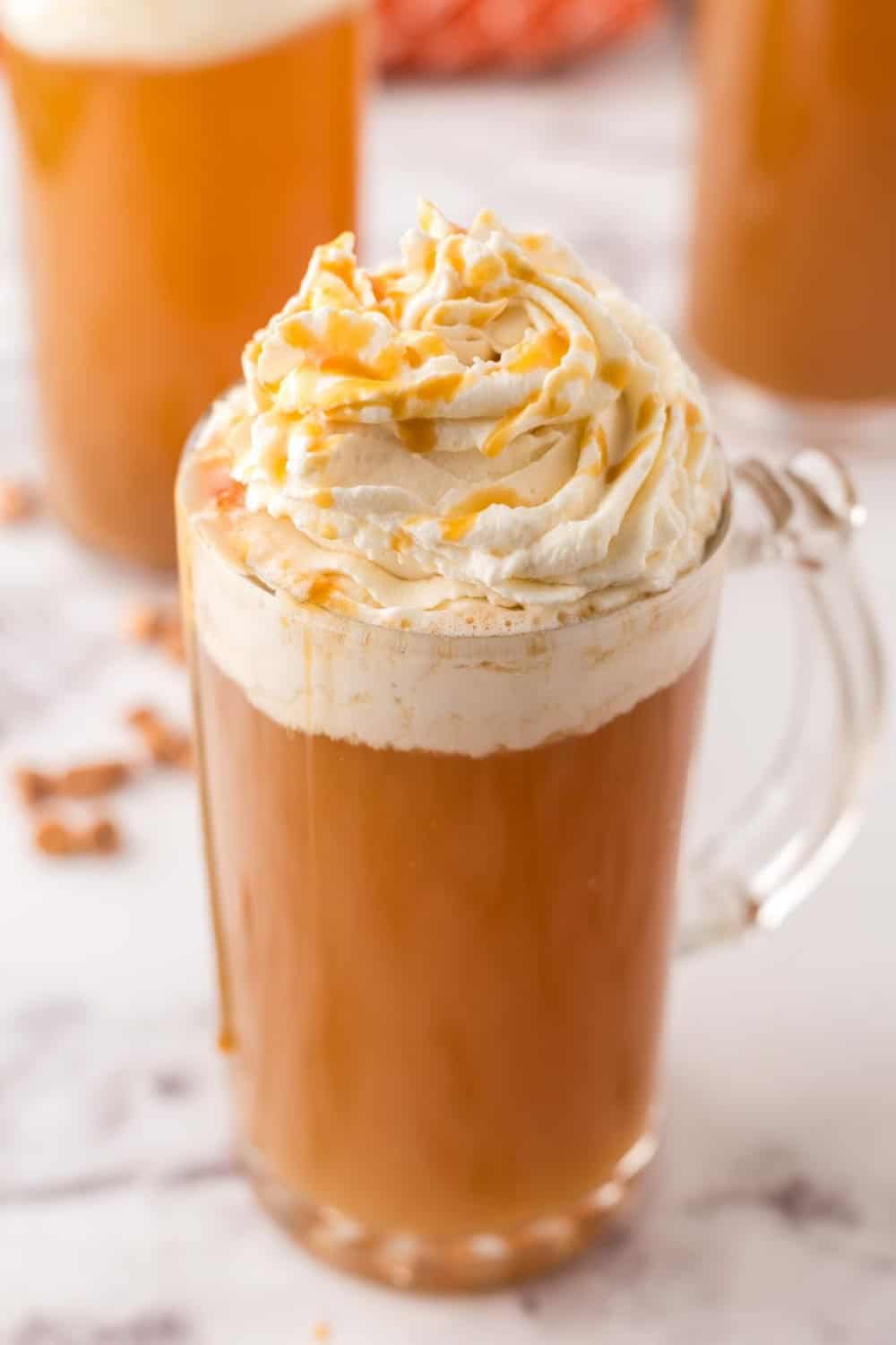 Delicious butterbeer served in a glass mug topped with whipped cream.