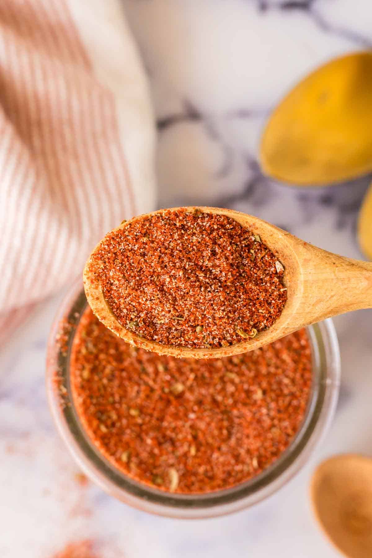 top view of a small dish with cajun seasoning with a wooden spoon