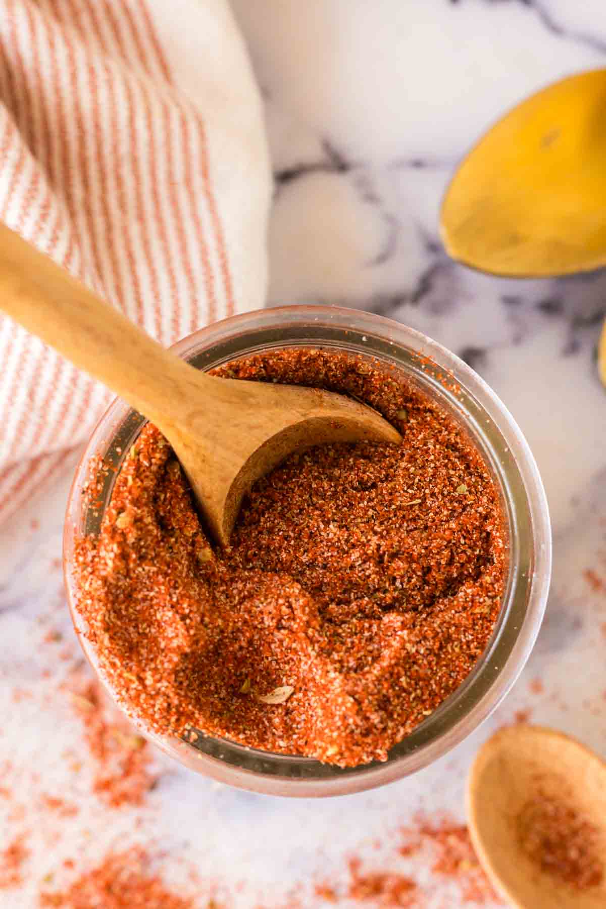 top view of a small dish with cajun seasoning with a wooden spoon