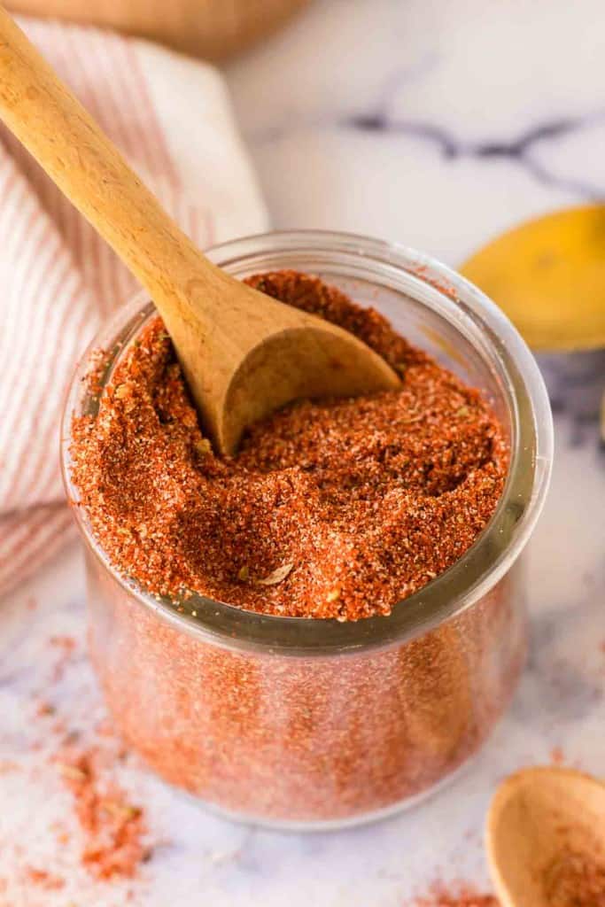 a small dish with cajun seasoning with a wooden spoon