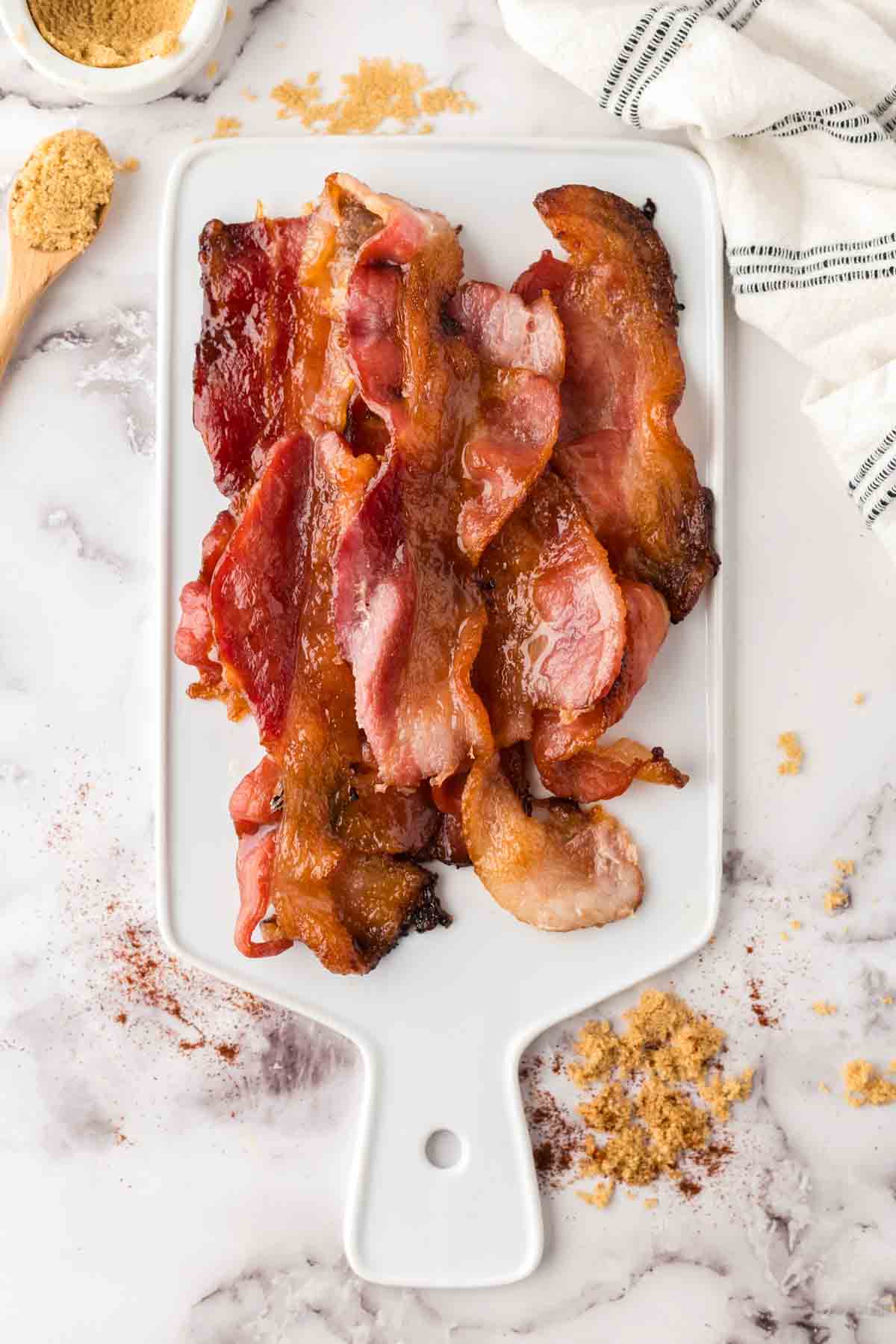 stack of candied bacon on a white tray