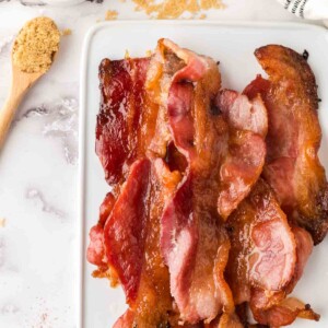 stack of candied bacon on a white tray