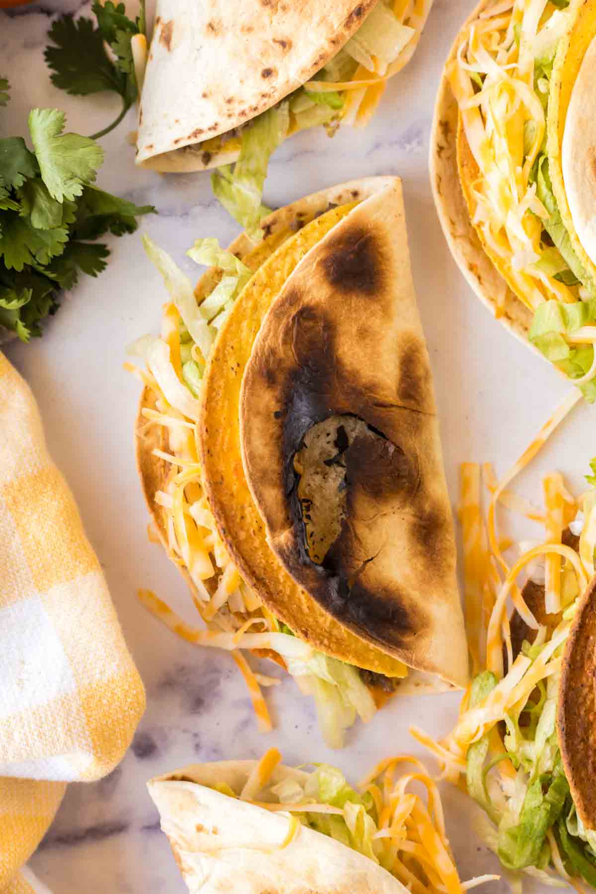 top view of a plate of cheesy gordita crunch shells filled with met and shredded lettuce