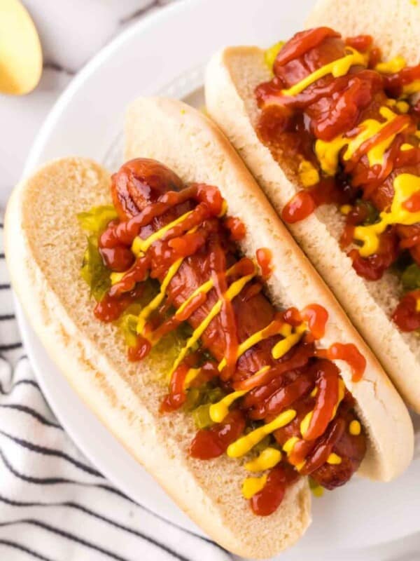two brats with ketchup mustard and relish in a traditional bun.