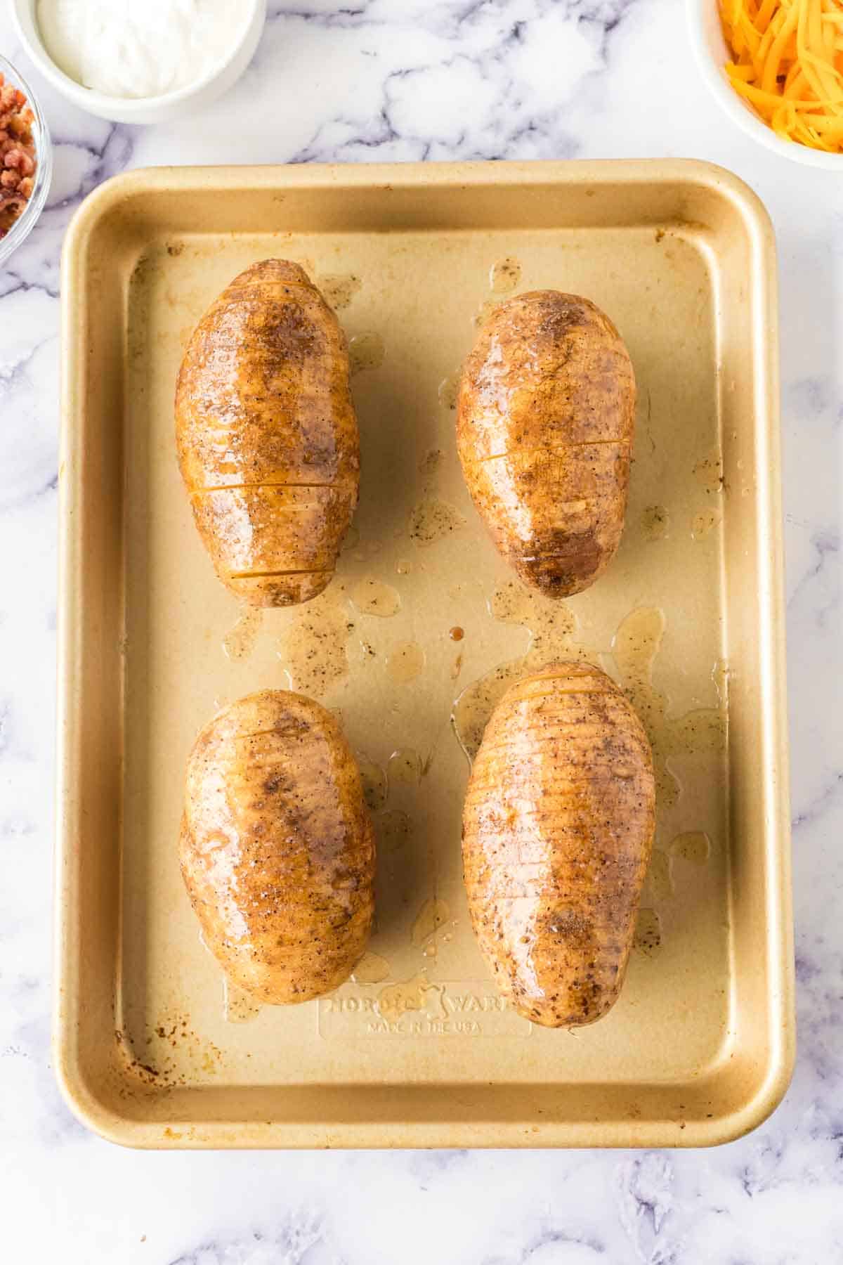 hasselback potatoes on a baking sheet