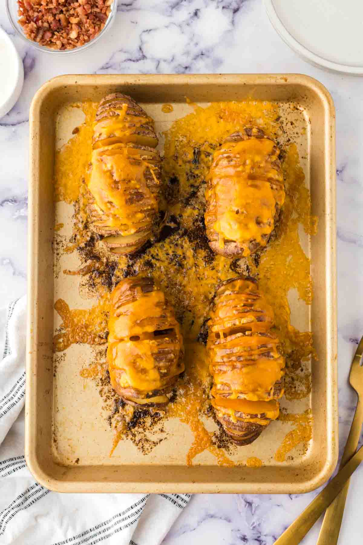 hasselback potatoes with meted cheese on a baking dish