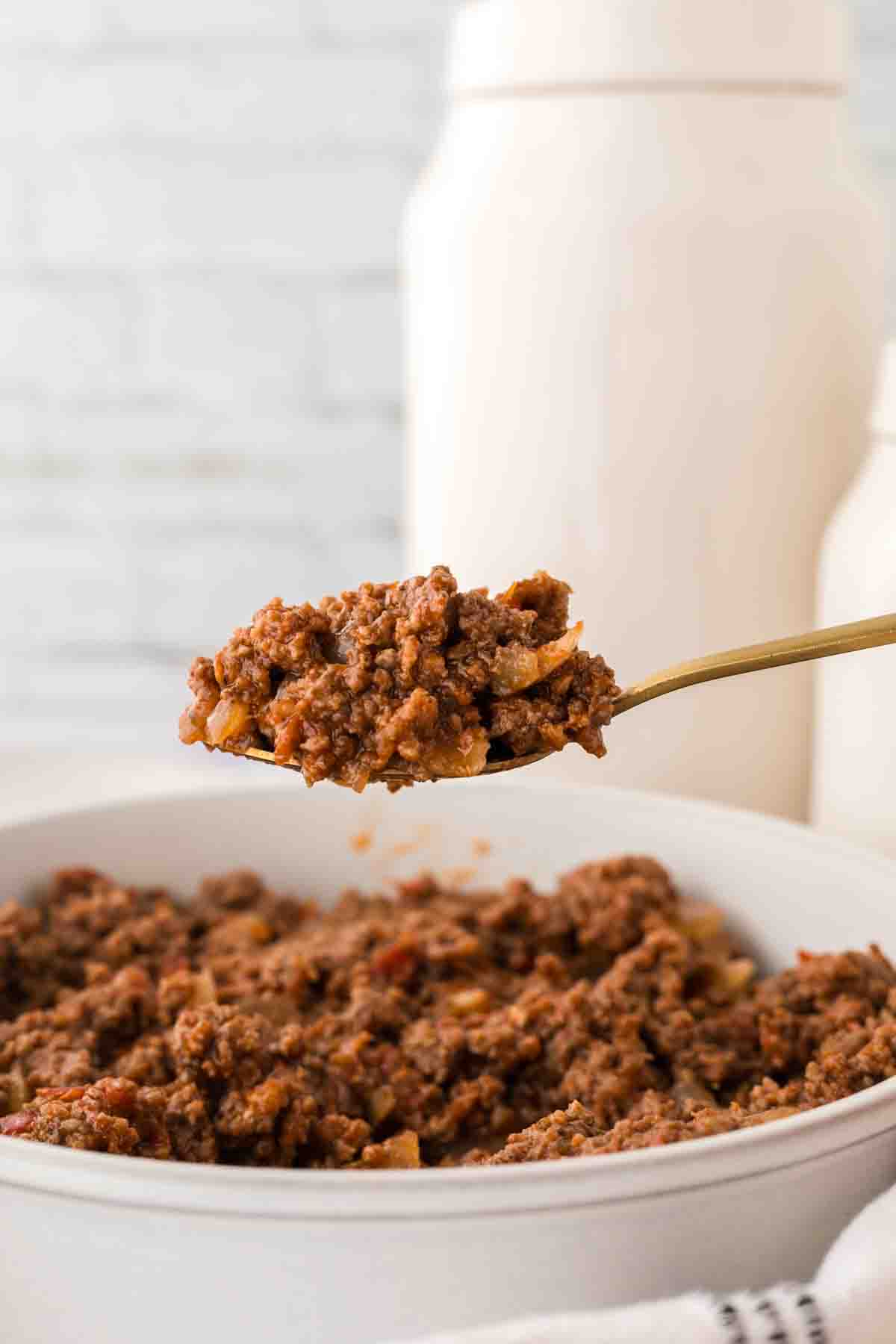 side view spoonful of hot dog chili recipe over a bowl