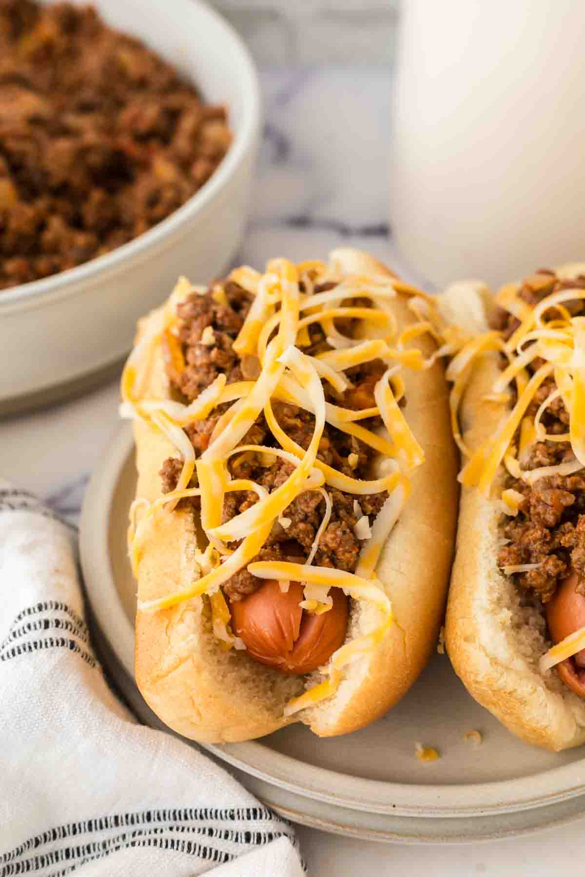 end view of two chili dogs on a plate