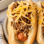 end view of two chili dogs on a plate.