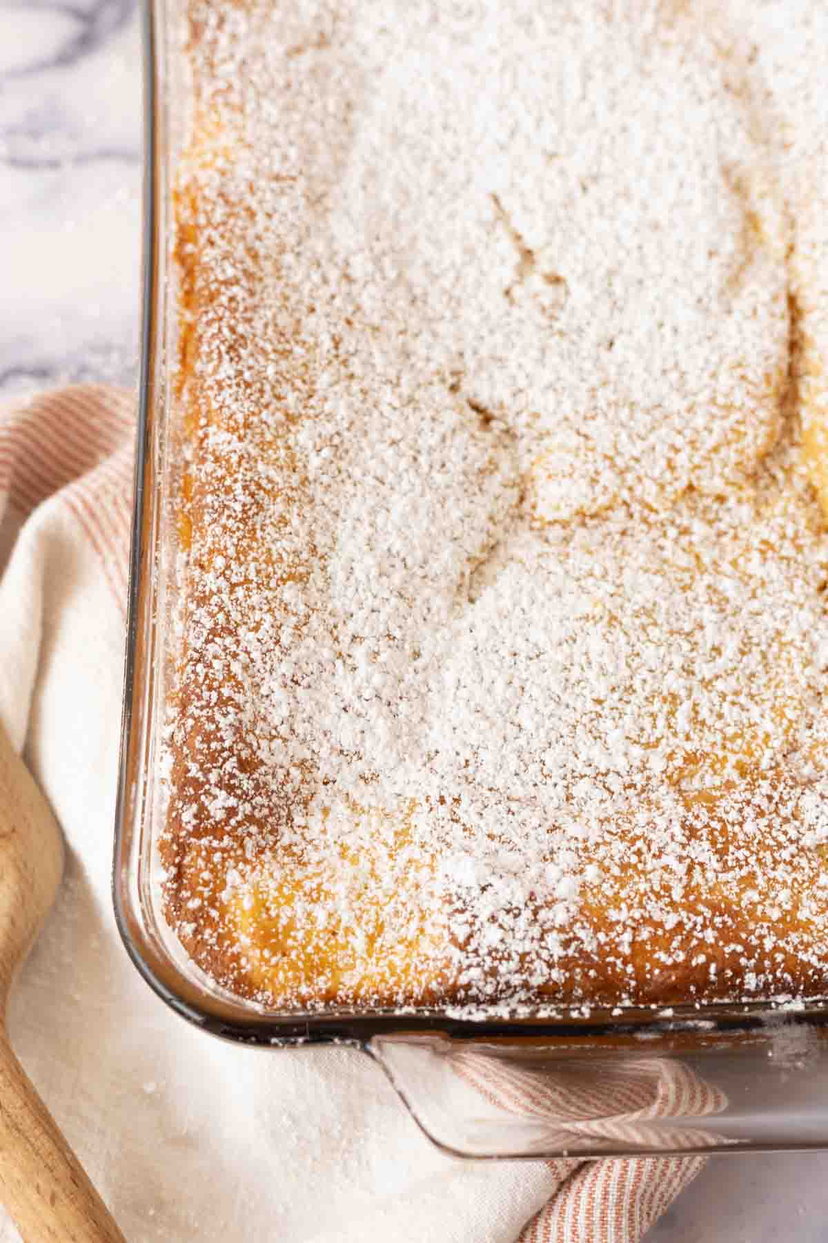 ugly cake recipe baked in the dish and dusted with powdered sugar