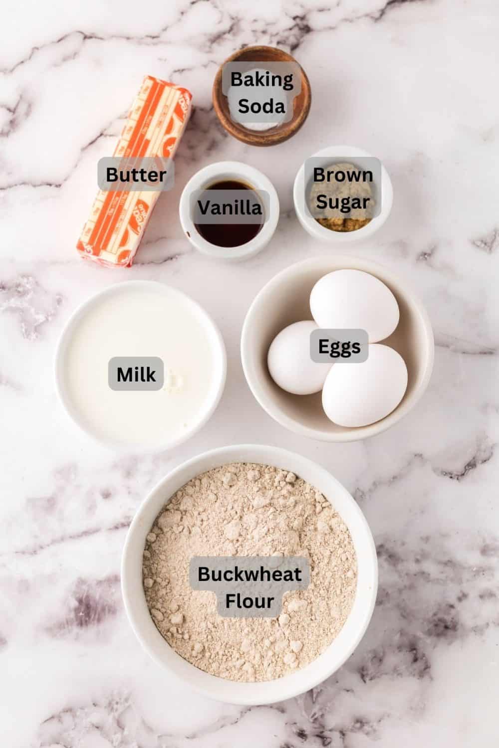 top view of digitally labeled portion dishes of raw ingredients for buckwheat pancakes recipe