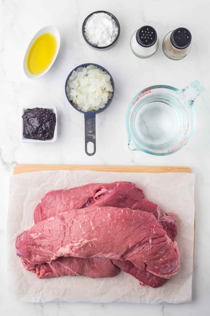 portion bowls each with raw ingredients to make round steak beef and gravy recipe.