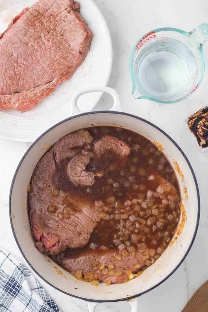 round beef steak and sautéed onions in the progress of cooking to make gravy.