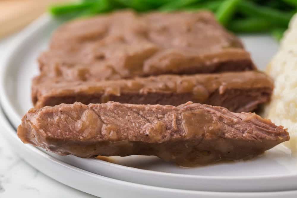 cooked round beef steak and gravy served with dinner.