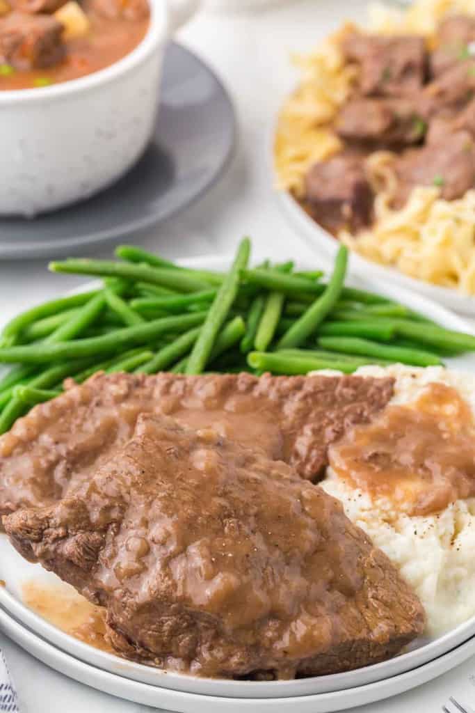 cooked round beef steak and gravy served with dinner.