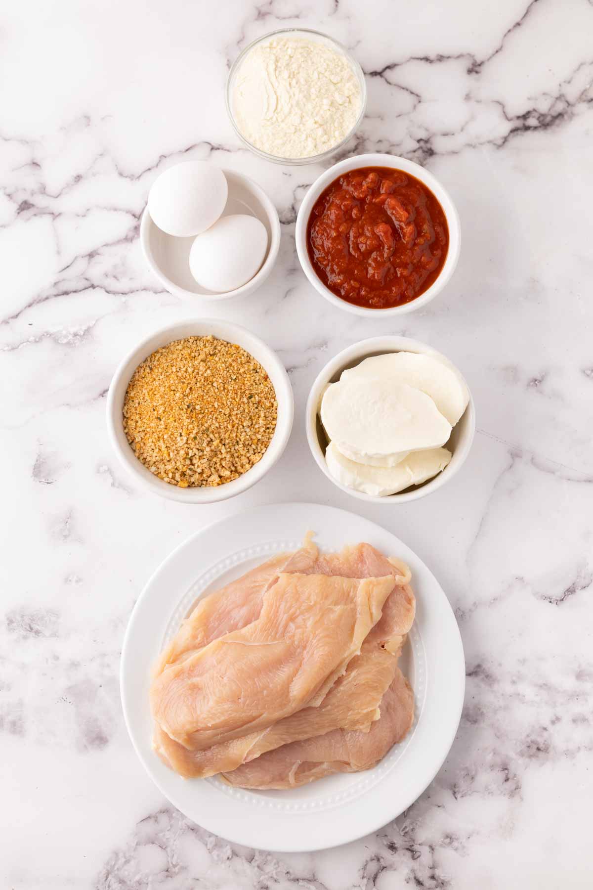 portion bowls each raw ingredient to make air fried chicken parmesan recipe.