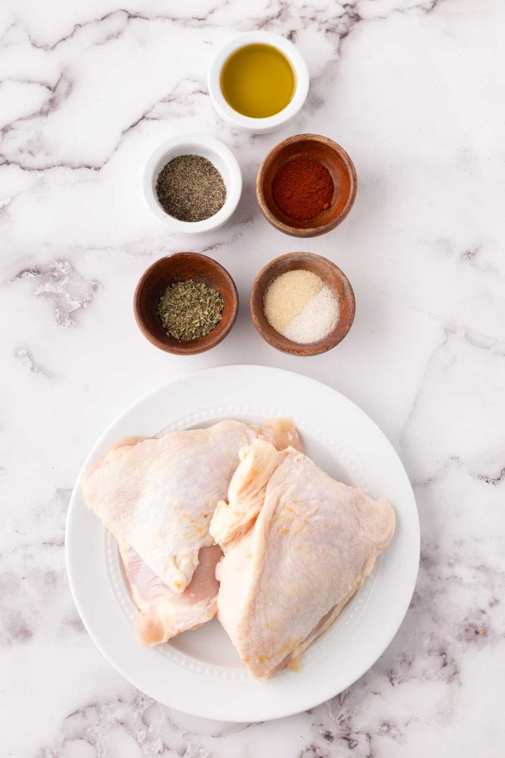 portion bowls each raw ingredient to season air fryer chicken thighs.