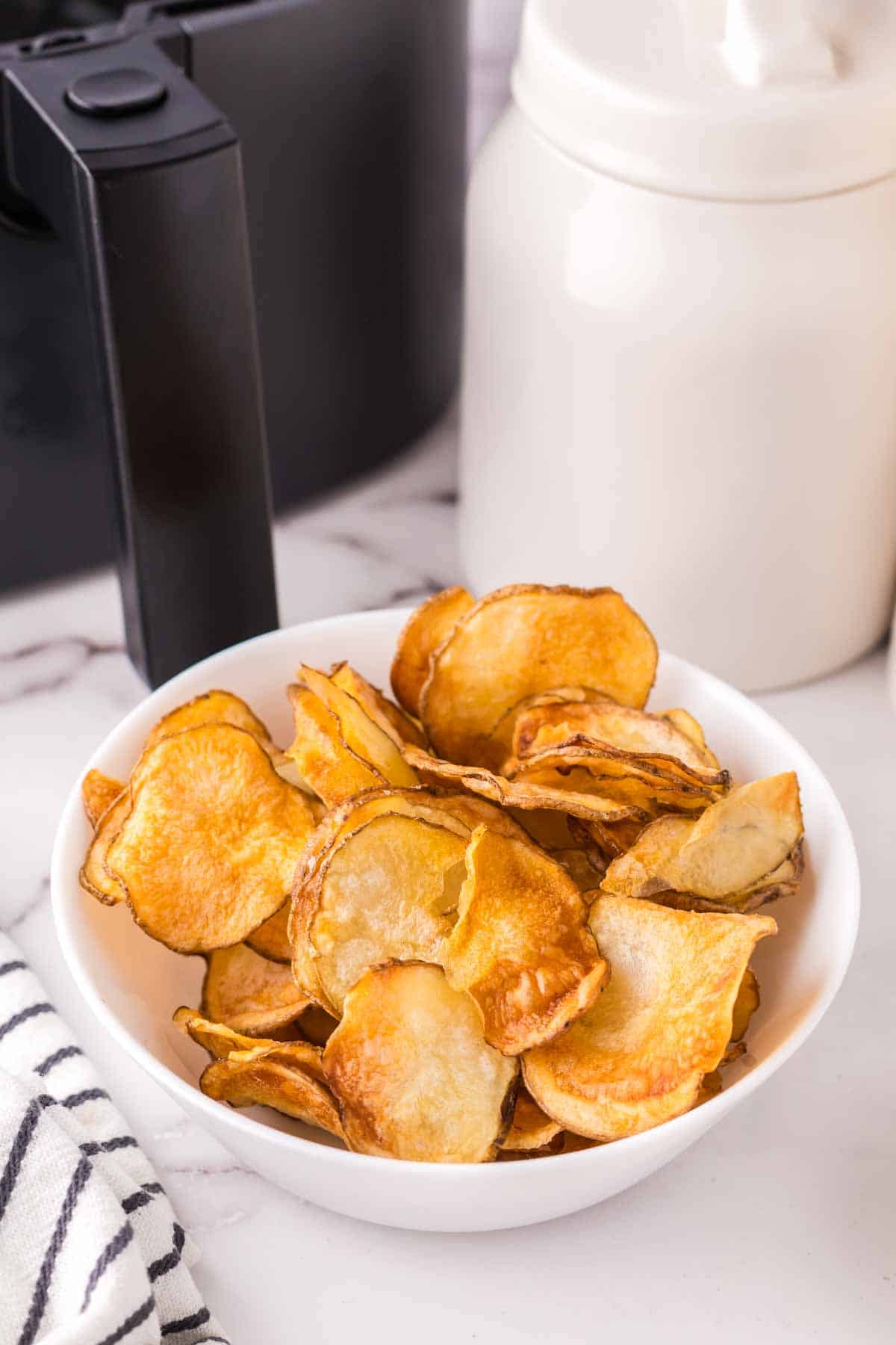 air fried potato chips in a white bowl.