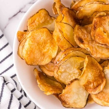 air fried potato chips in a white bowl.