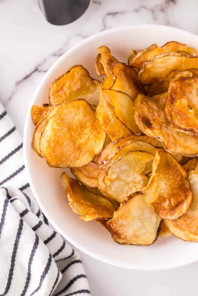air fried potato chips in a white bowl.