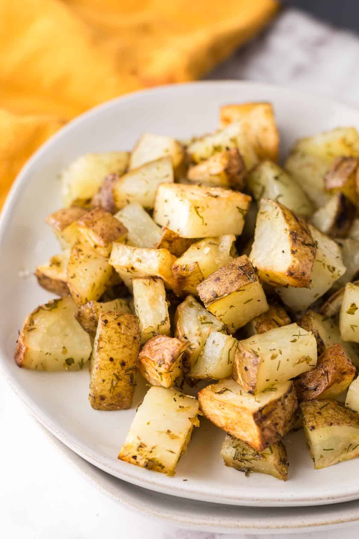 air fryer roasted potatoes with herbs on a plate.