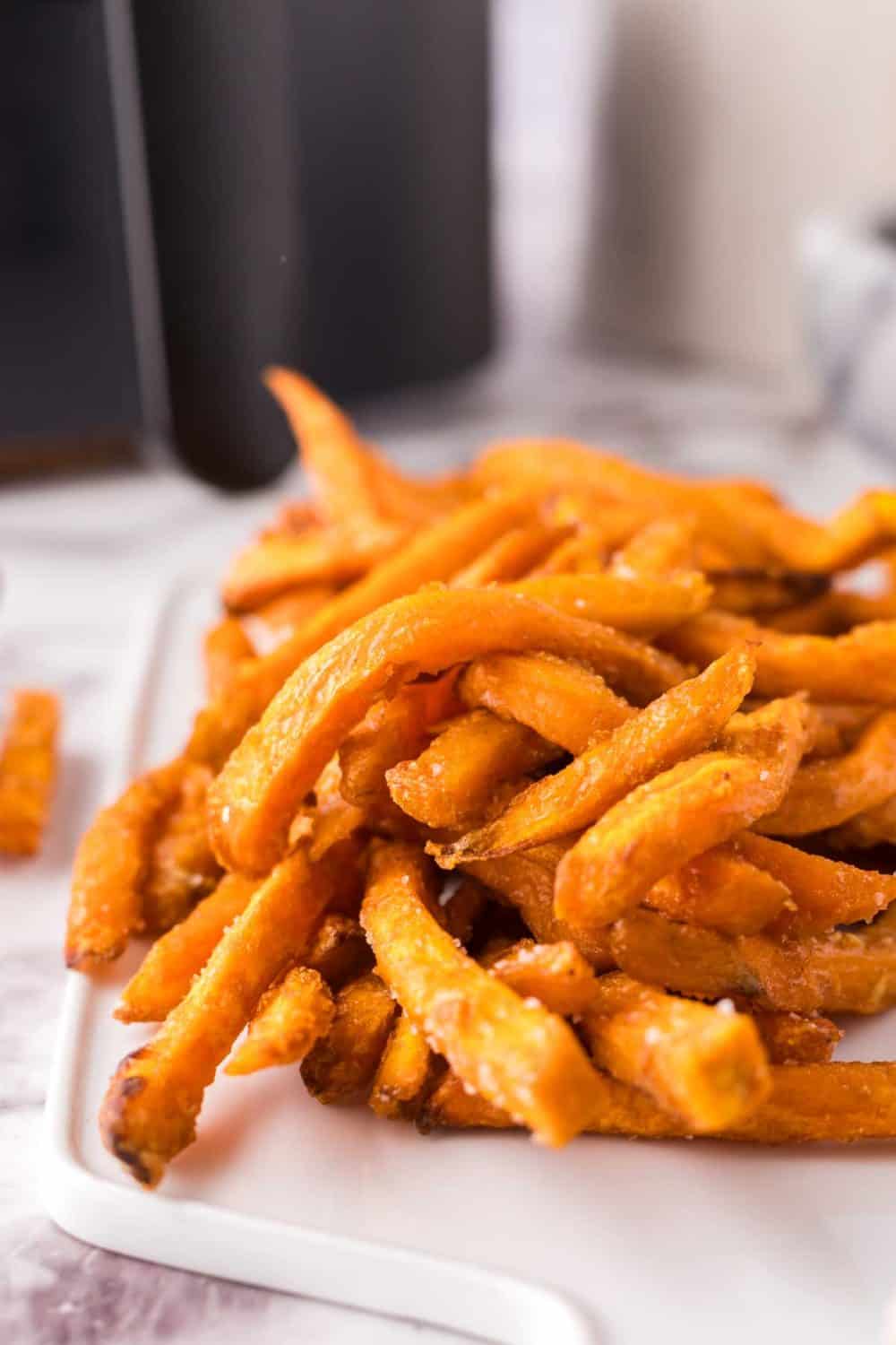 air fried sweet potato french fries on a white cutting board.