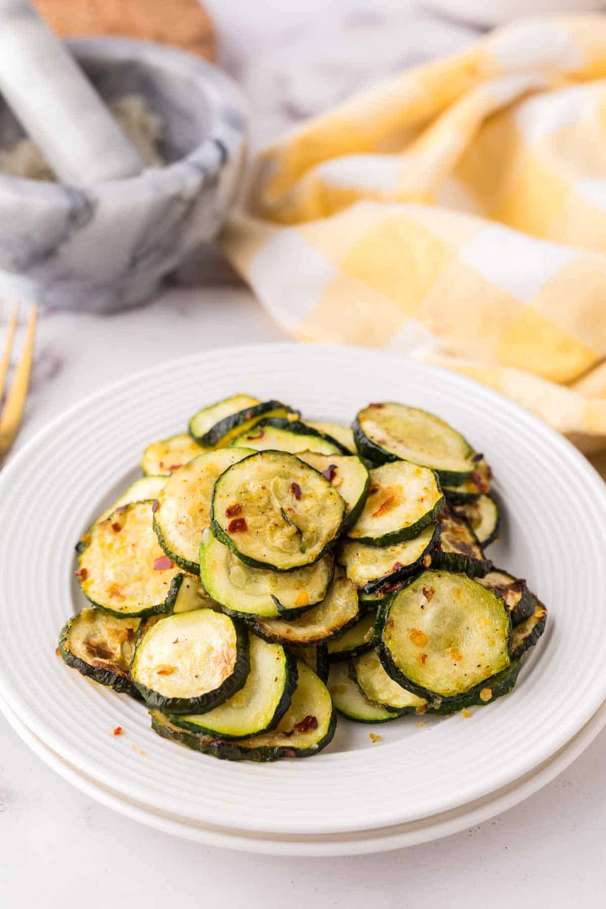 air fryer zucchini on a white plate.