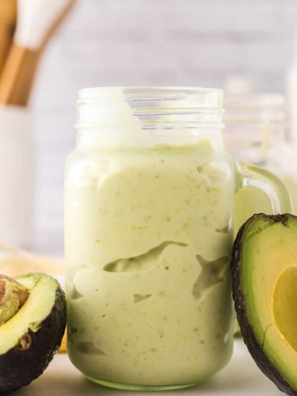 handled glass mason jar filled with avocado smoothie.