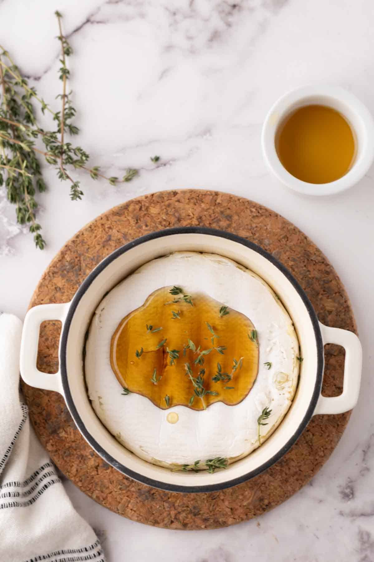 baked brie wheel in a dutch pot with thyme and honey.