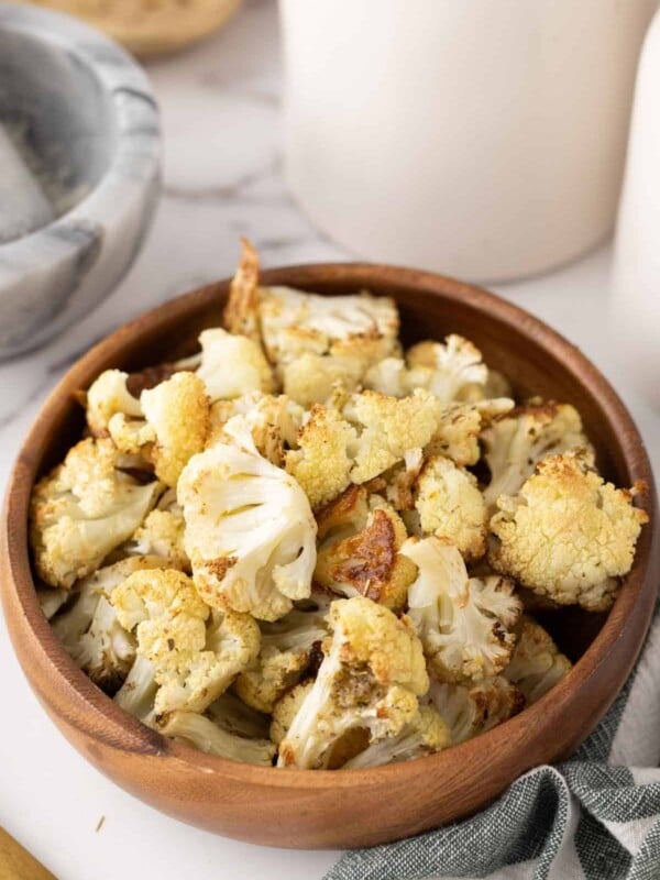 baked cauliflower florets in a wooden bowl.