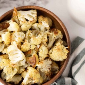 baked cauliflower florets in a wooden bowl.