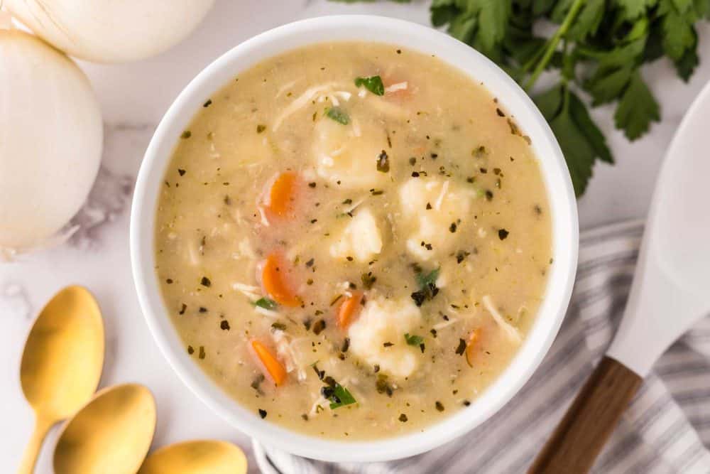 bisquick dumplings recipe in a white bowl with golden spoons.