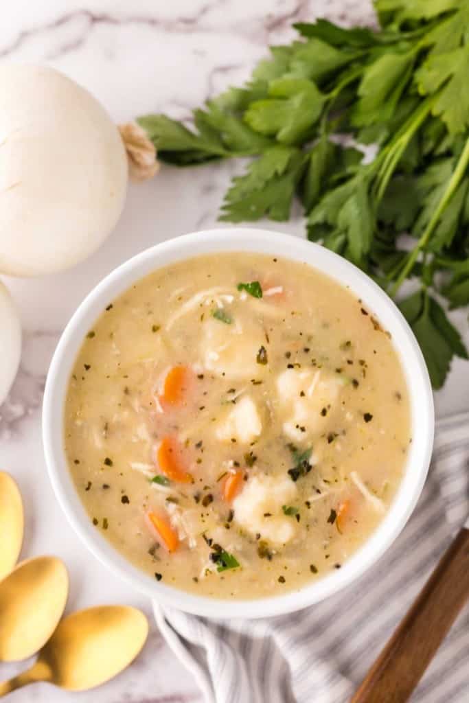 bisquick dumplings recipe in a white bowl with golden spoons.