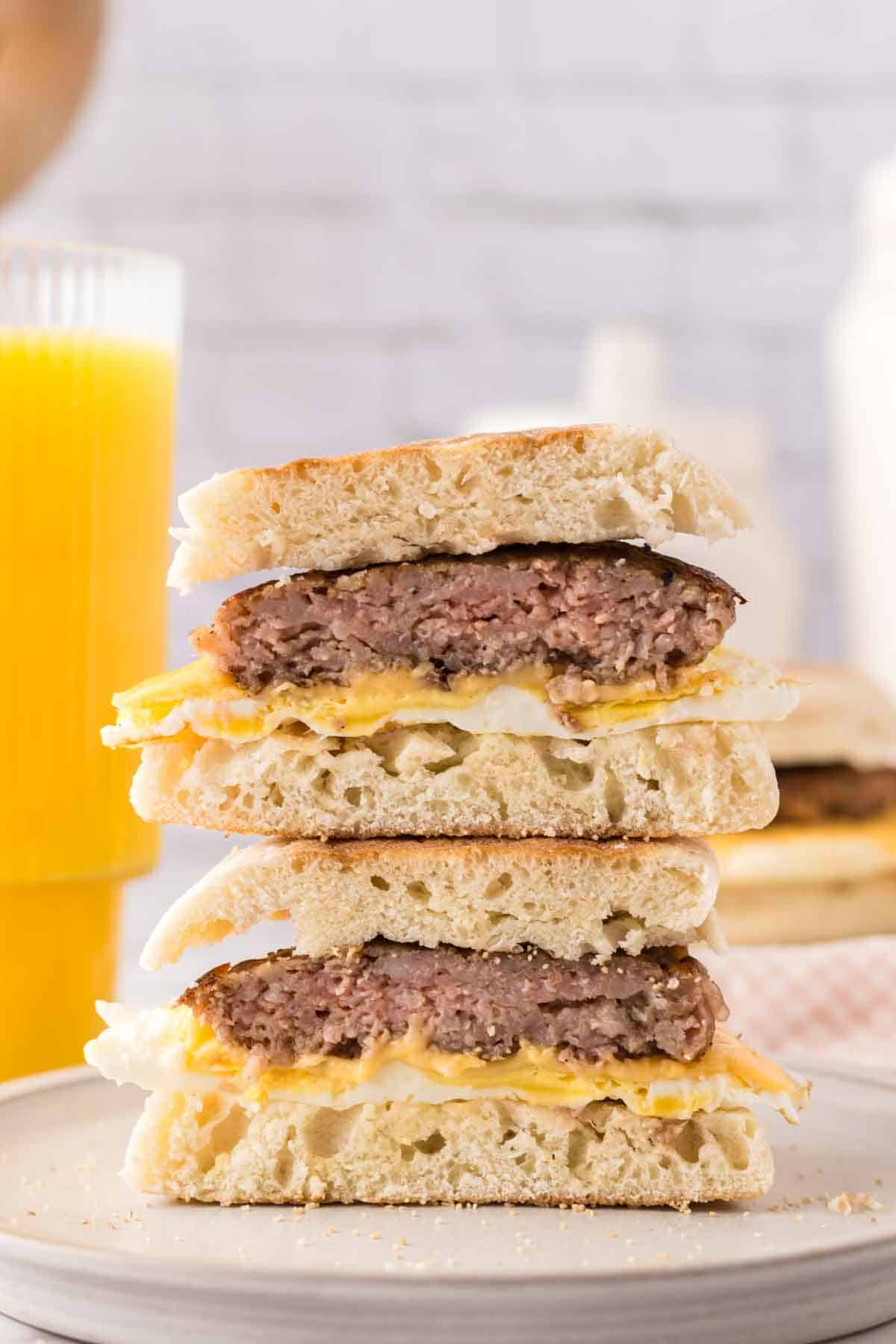 English muffin egg and sausage breakfast sandwich cut in half.