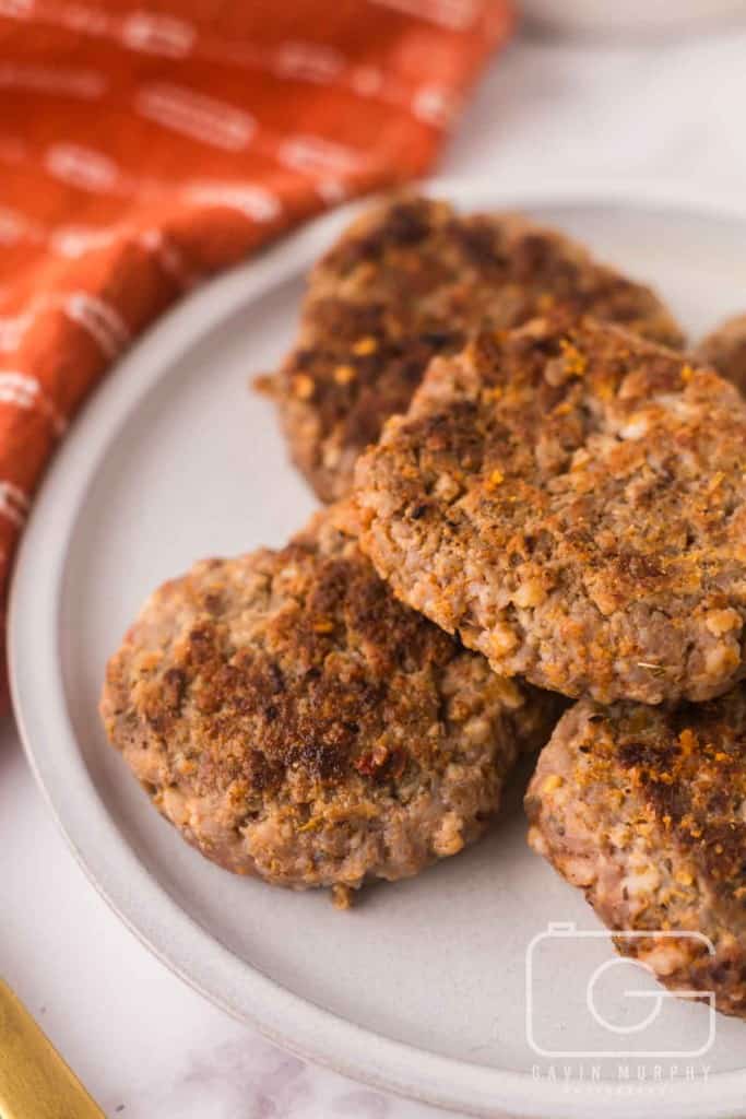 round plate with a stack of homemade breakfast sausage.