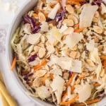 cabbage salad recipe in a white bowl with golden forks to the side.