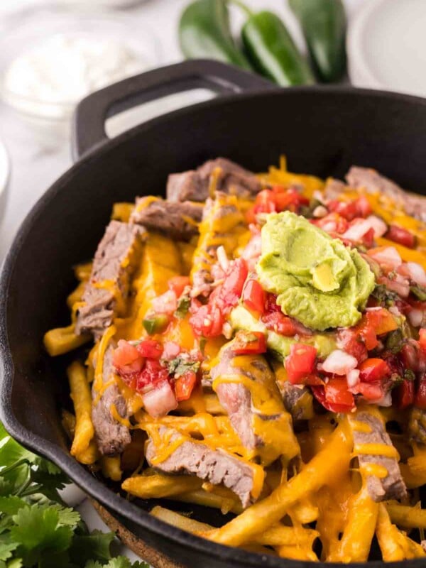 cast iron pan showing the progress of making carne asada fries recipe.