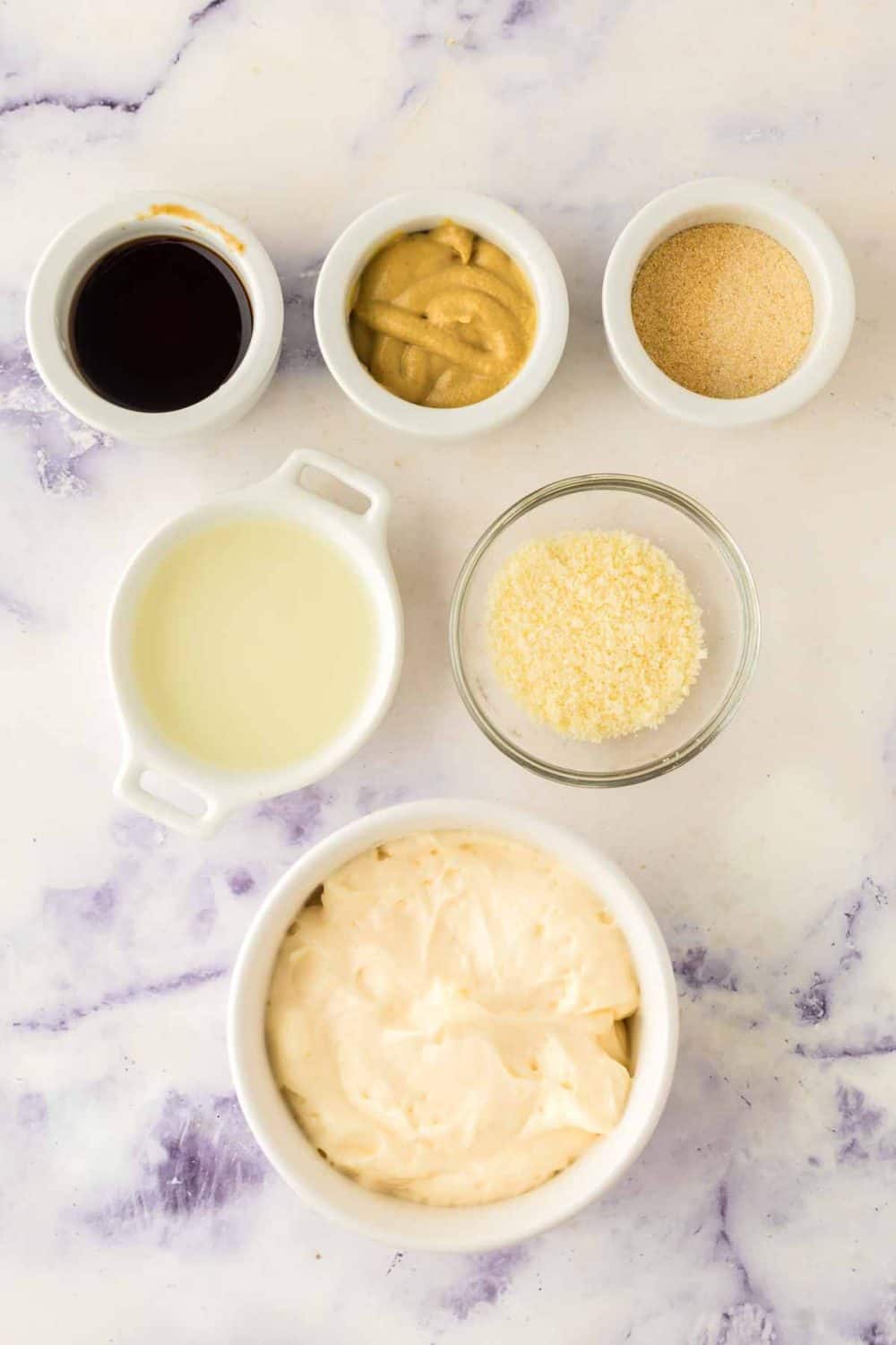 top view of portion dishes of raw ingredients for the caesar salad dressing recipe