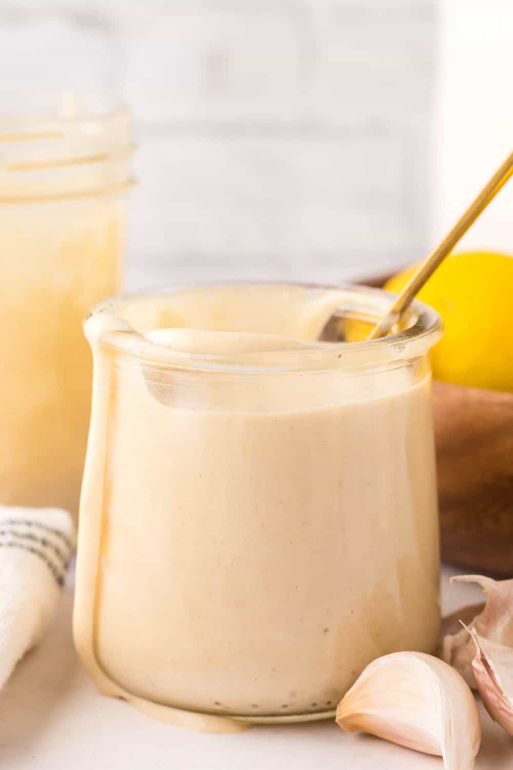 side view of homemade caesar dressing recipe in a small glass jar