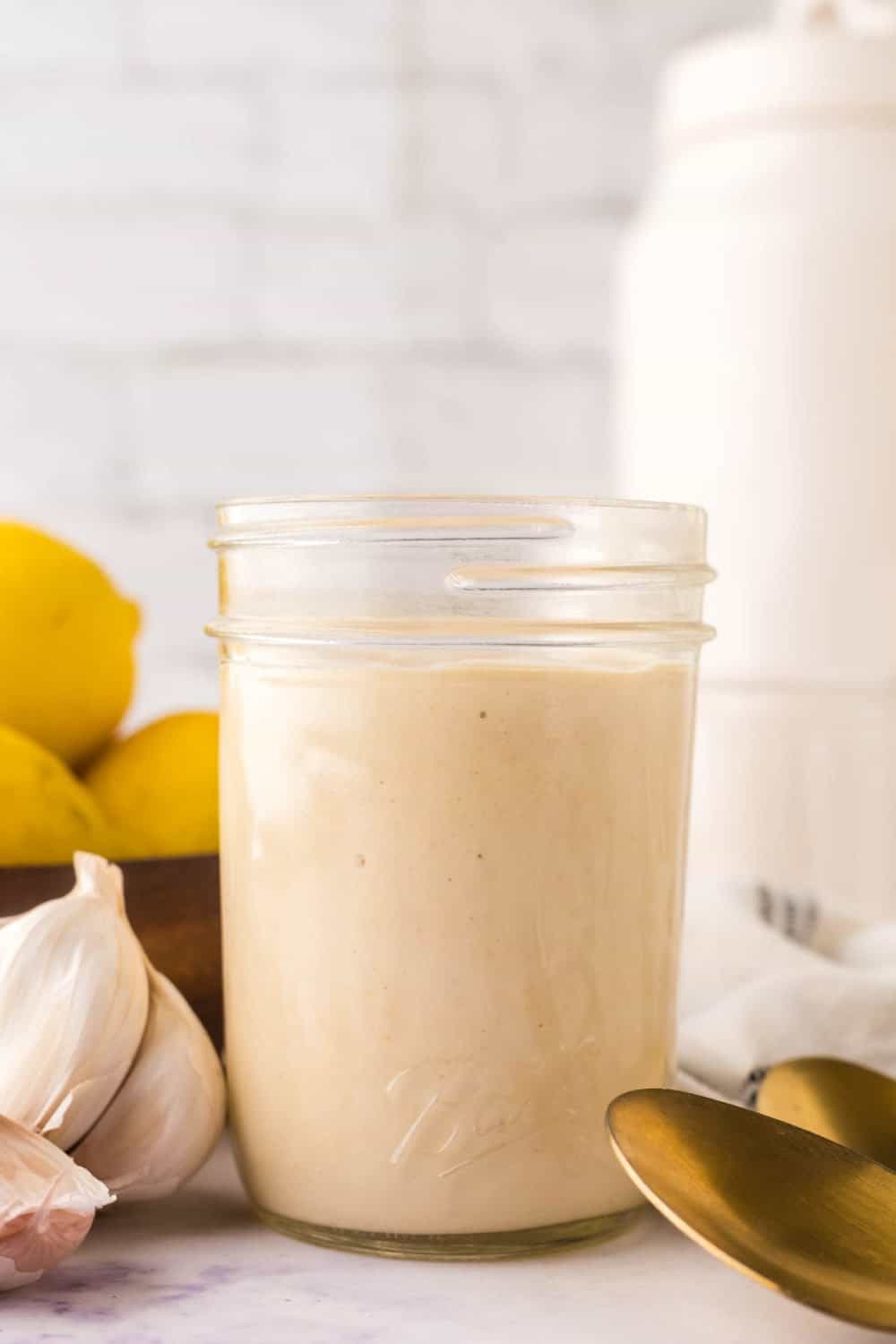 side view of a glass mason jar filled with caesar salad dressing