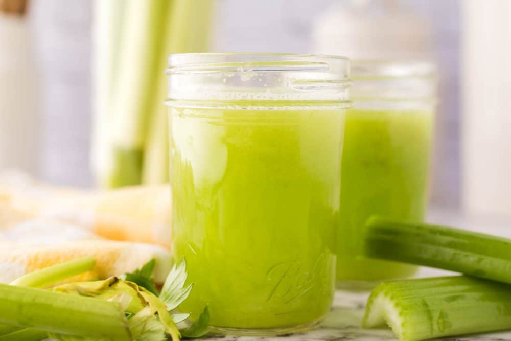 small mason jars with green celery juice.