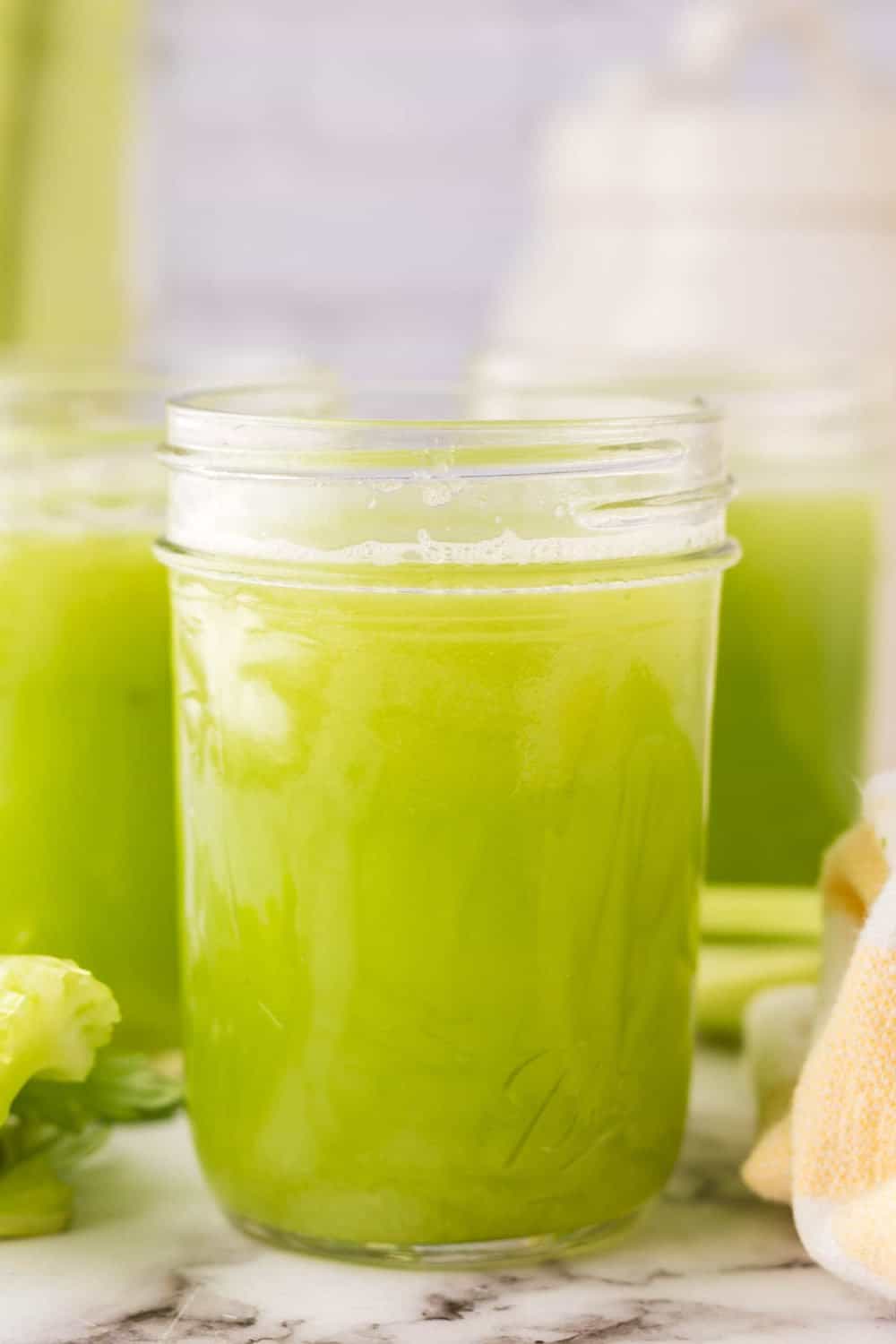 small mason jars with green celery juice.