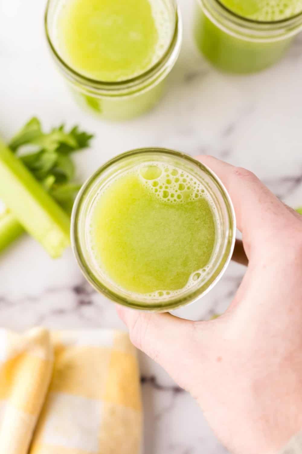 small mason jars filled with green celery juice.