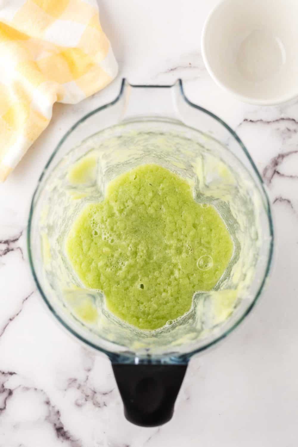 a blender with celery and water in the pitcher.