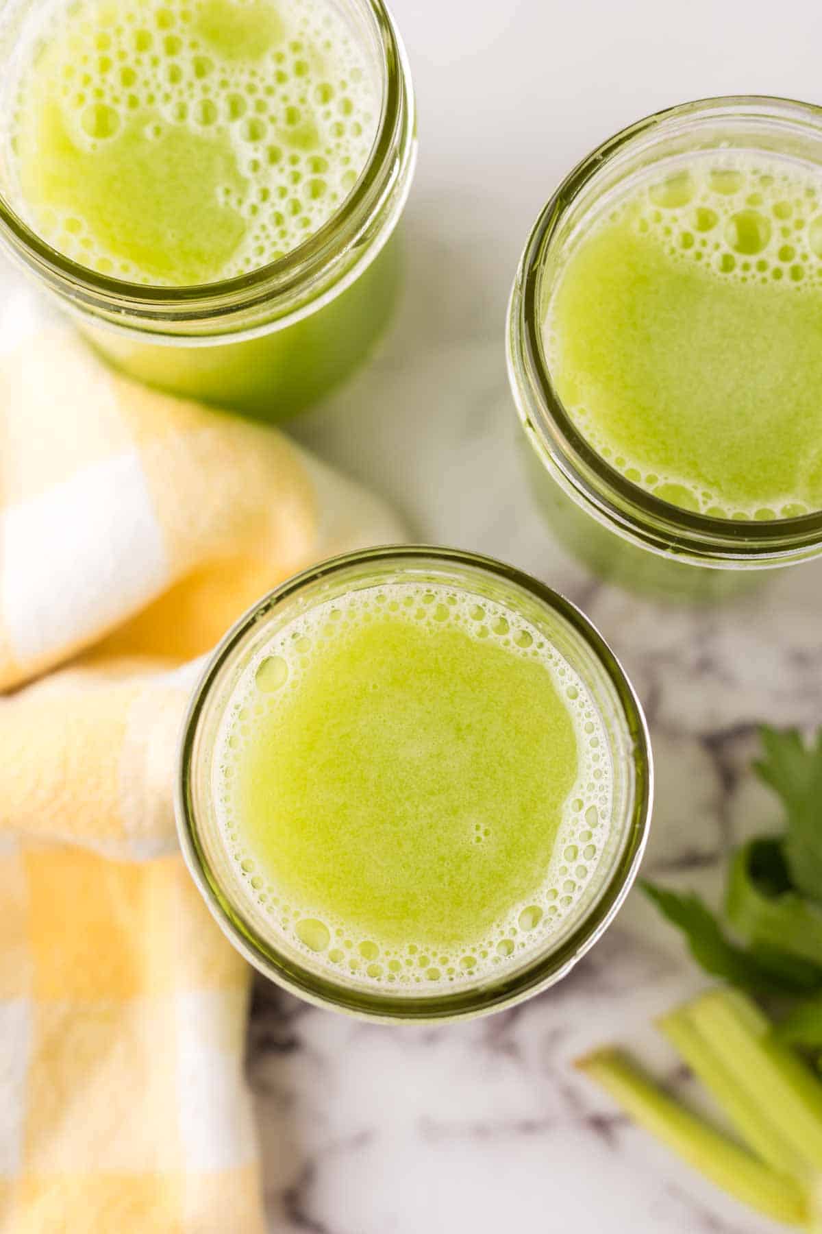 small mason jars with green celery juice.