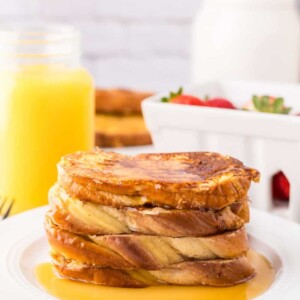 stack of challah french toast with syrup on top.