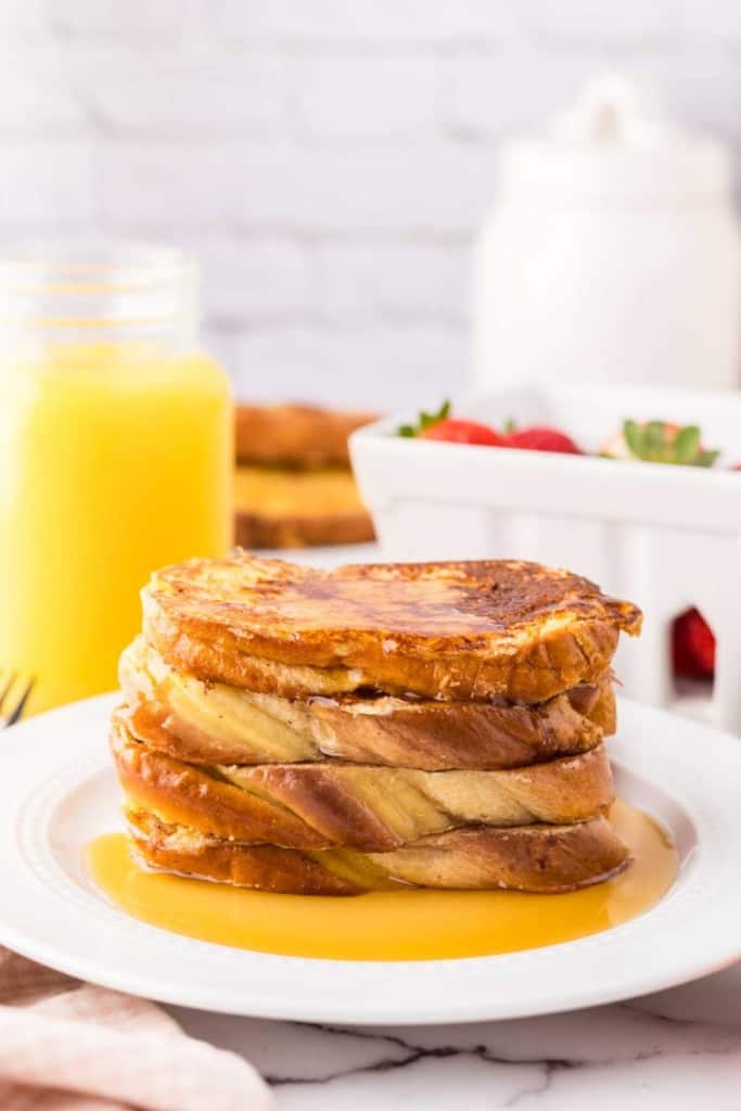 stack of challah french toast with syrup on top.